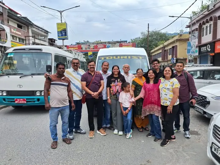 Family group with tourist bus departing India